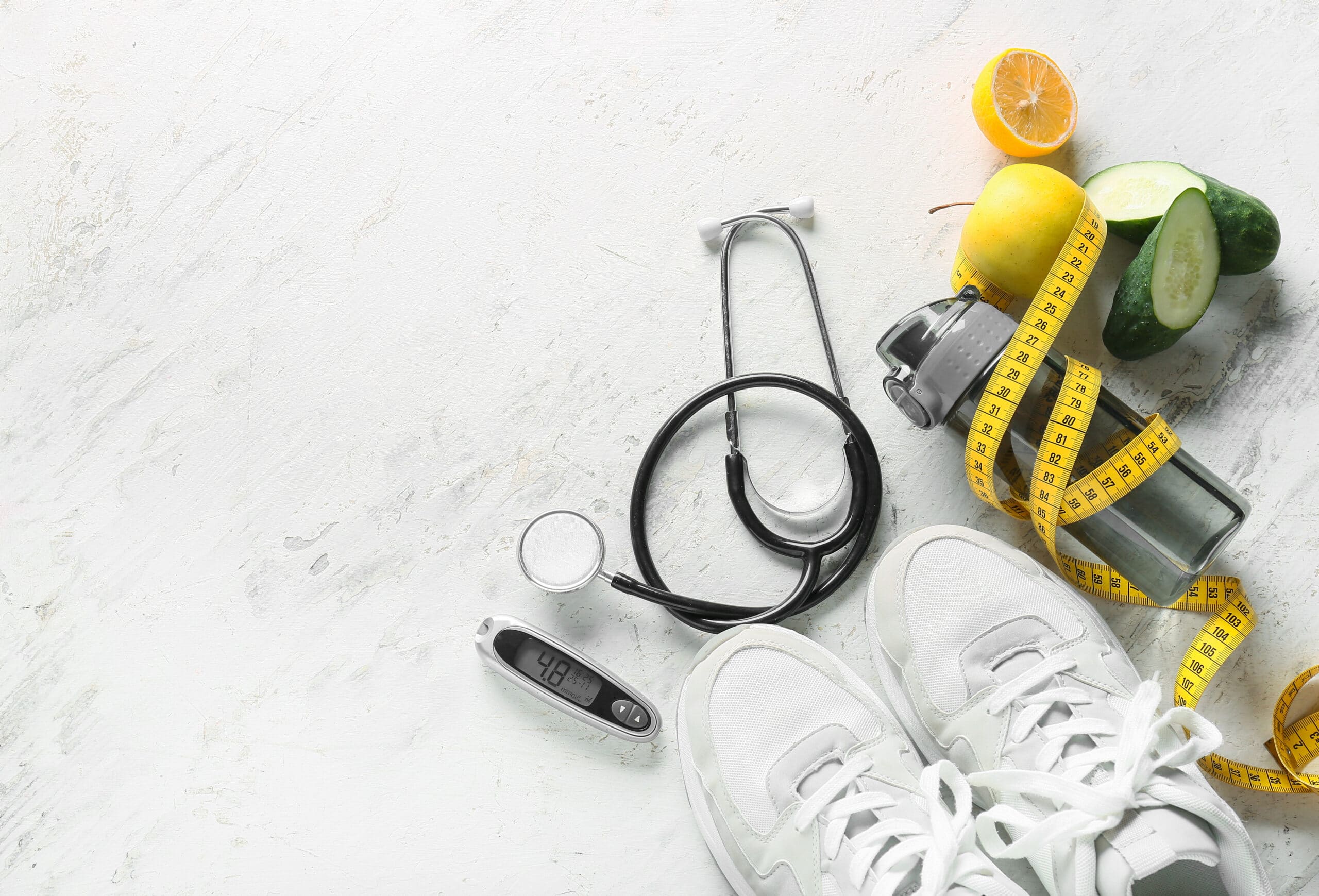 Sports shoes, measuring tape, stethoscope and glucometer on white background. Diabetes concept